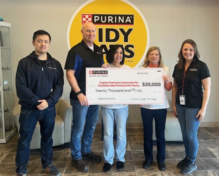 Five people stand indoors holding a $20,000 check from Purina for the Virginia Peninsula Community Pet Food Bank.