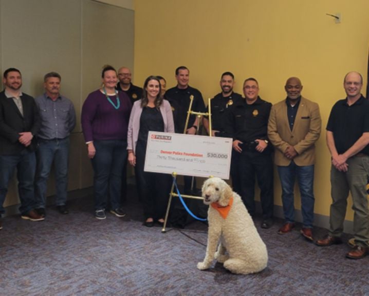 People stand holding a $30,000 check