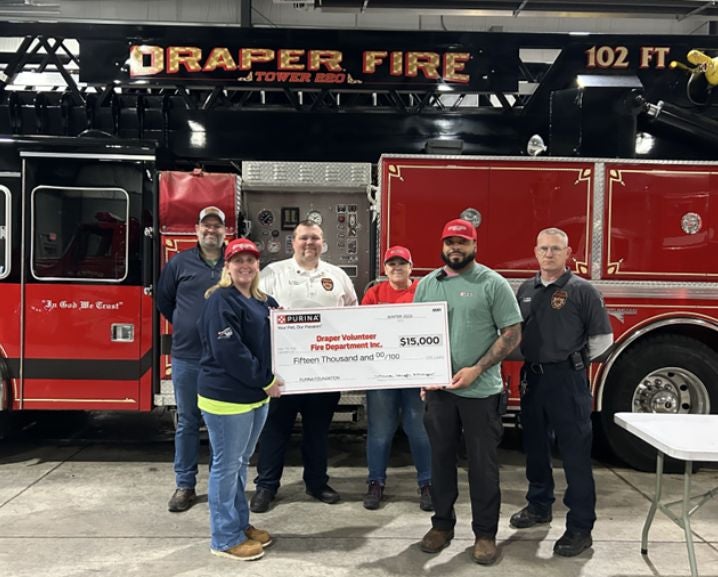 Group of people standing and holding a $20,000 Purina