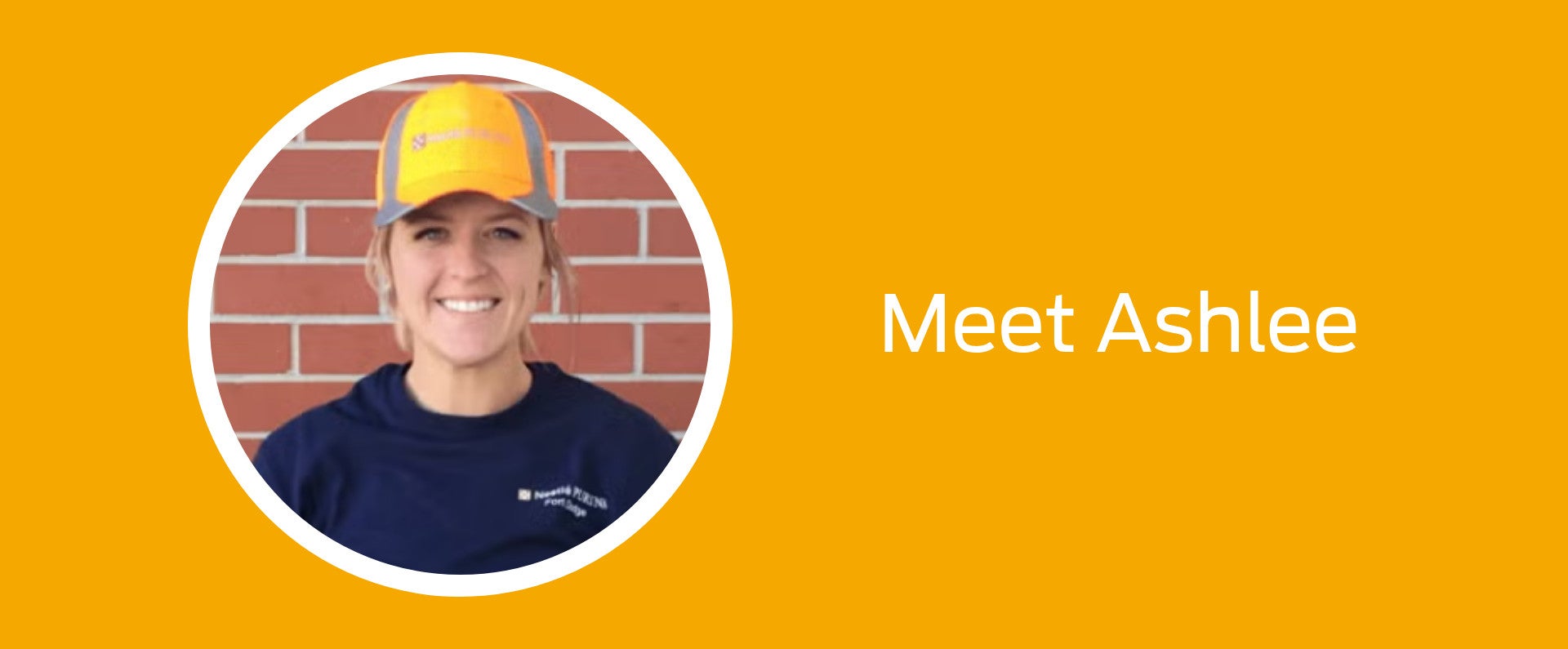 Smiling woman in a orange cap against a brick wall, text reads "Meet Ashlee"