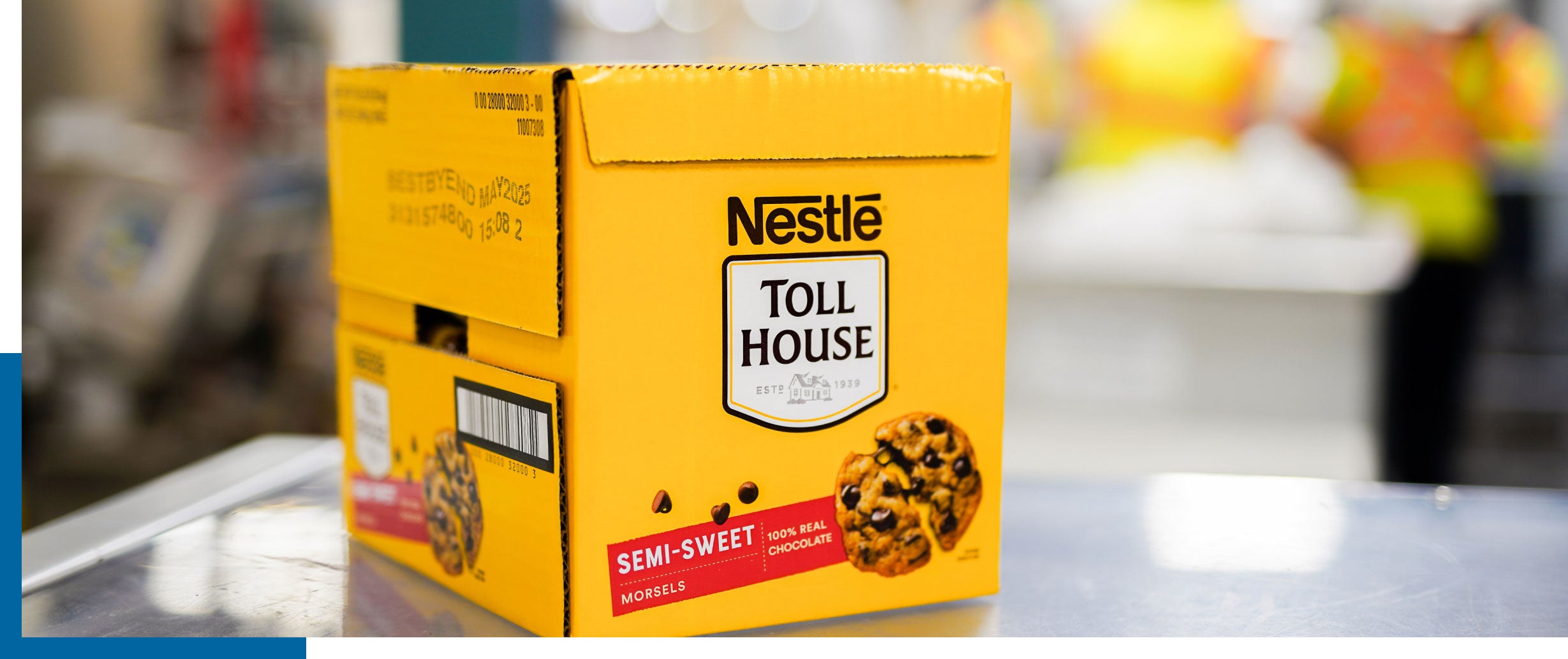 Yellow Nestlé Toll House box with a cookie graphic on a table, blurred background.