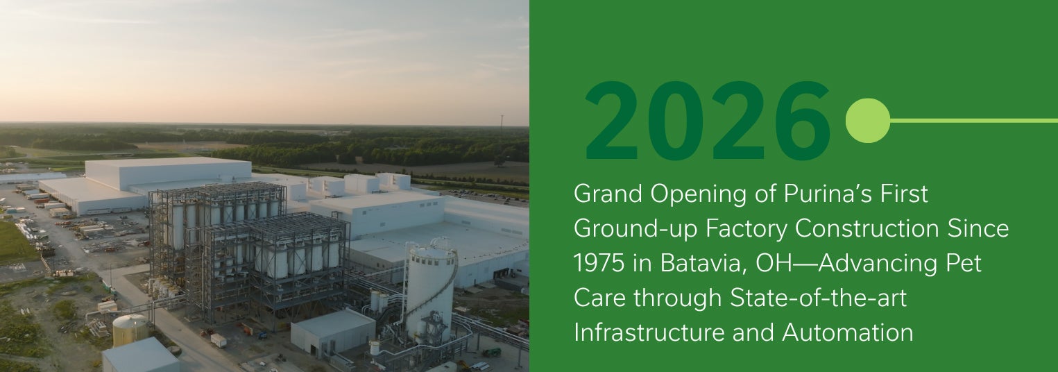 Aerial view of a large factory under construction next to green text about a 2026 grand opening.