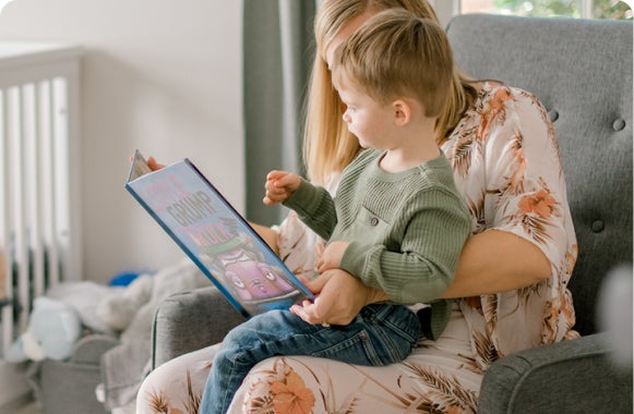 Mom reading to her son on her lap