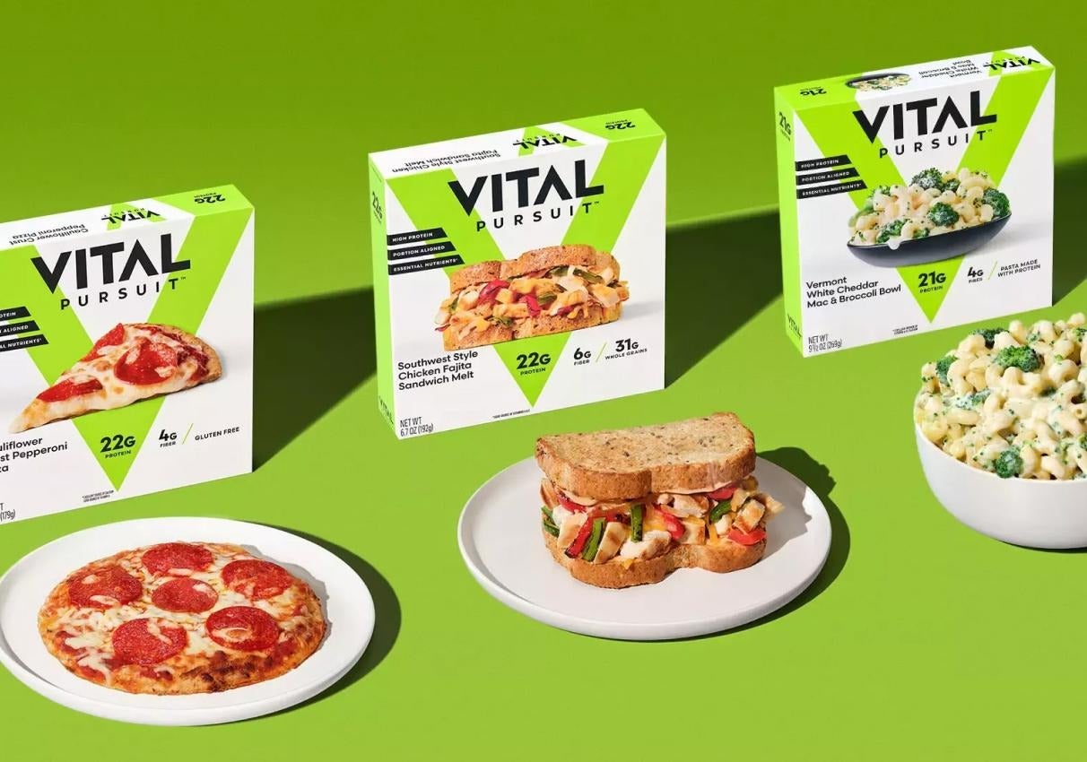 Three Vital Pursuit frozen meals with plated pizza, sandwich, and macaroni and cheese.
