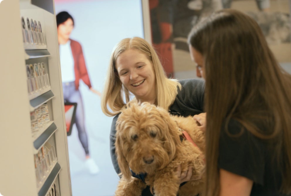 Associate smiling while holding a golden doodle