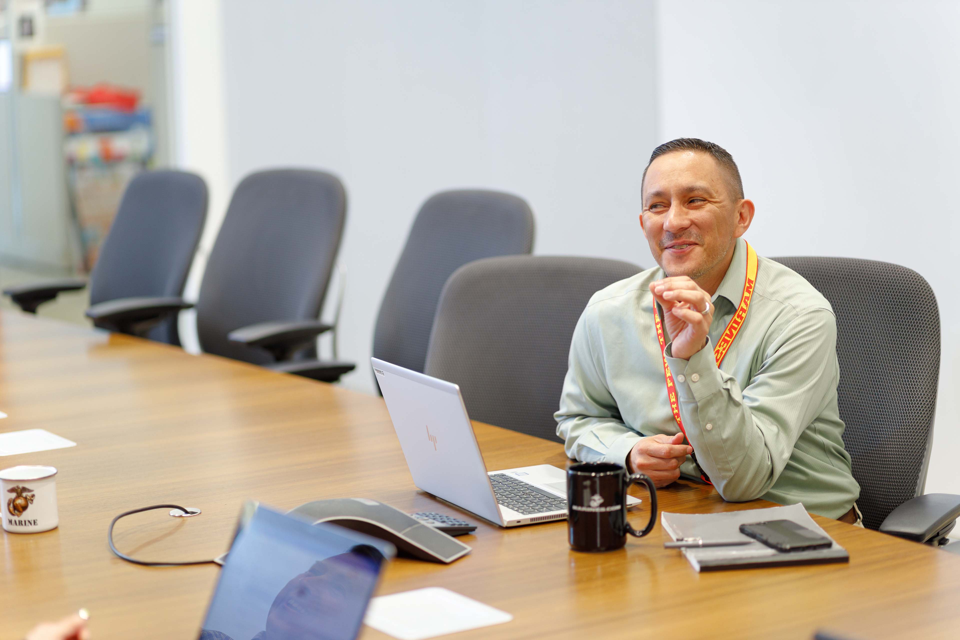 A man sits at the table in the meeting room and talks to someone