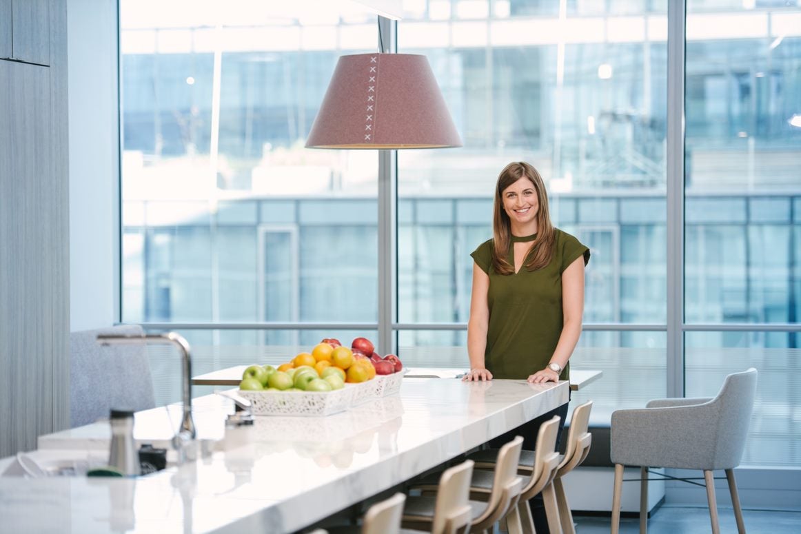 Woman standing in office building smiling at camera 