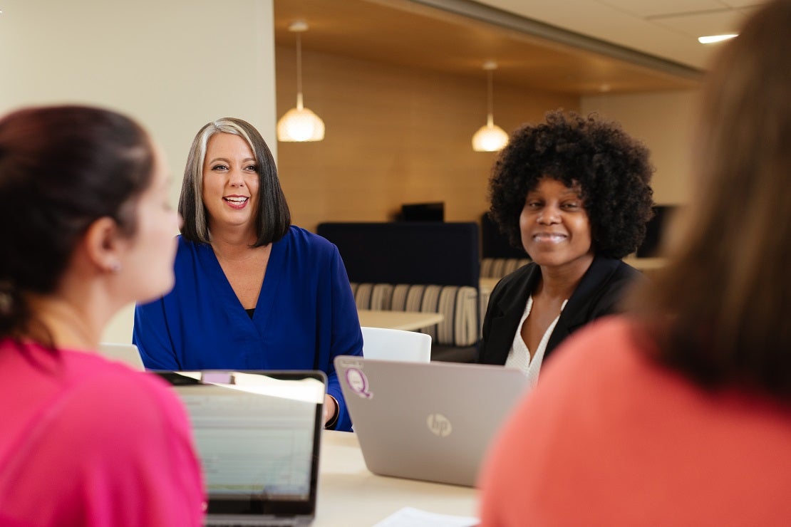 Female associates talking in an office