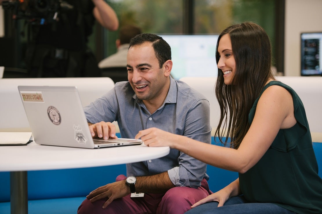 Male and female associates working on a computer together