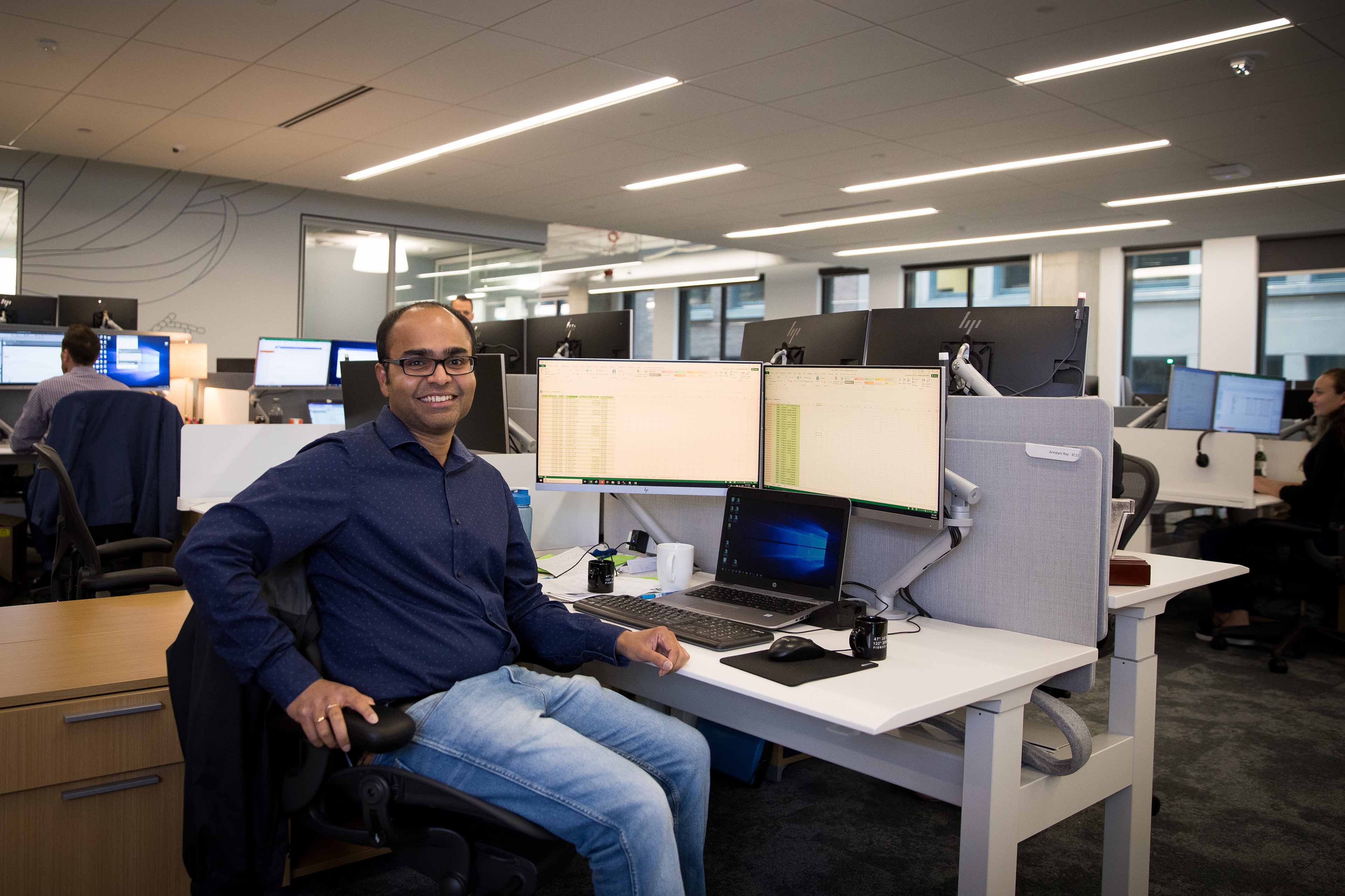 Man smiling in his chair at work
