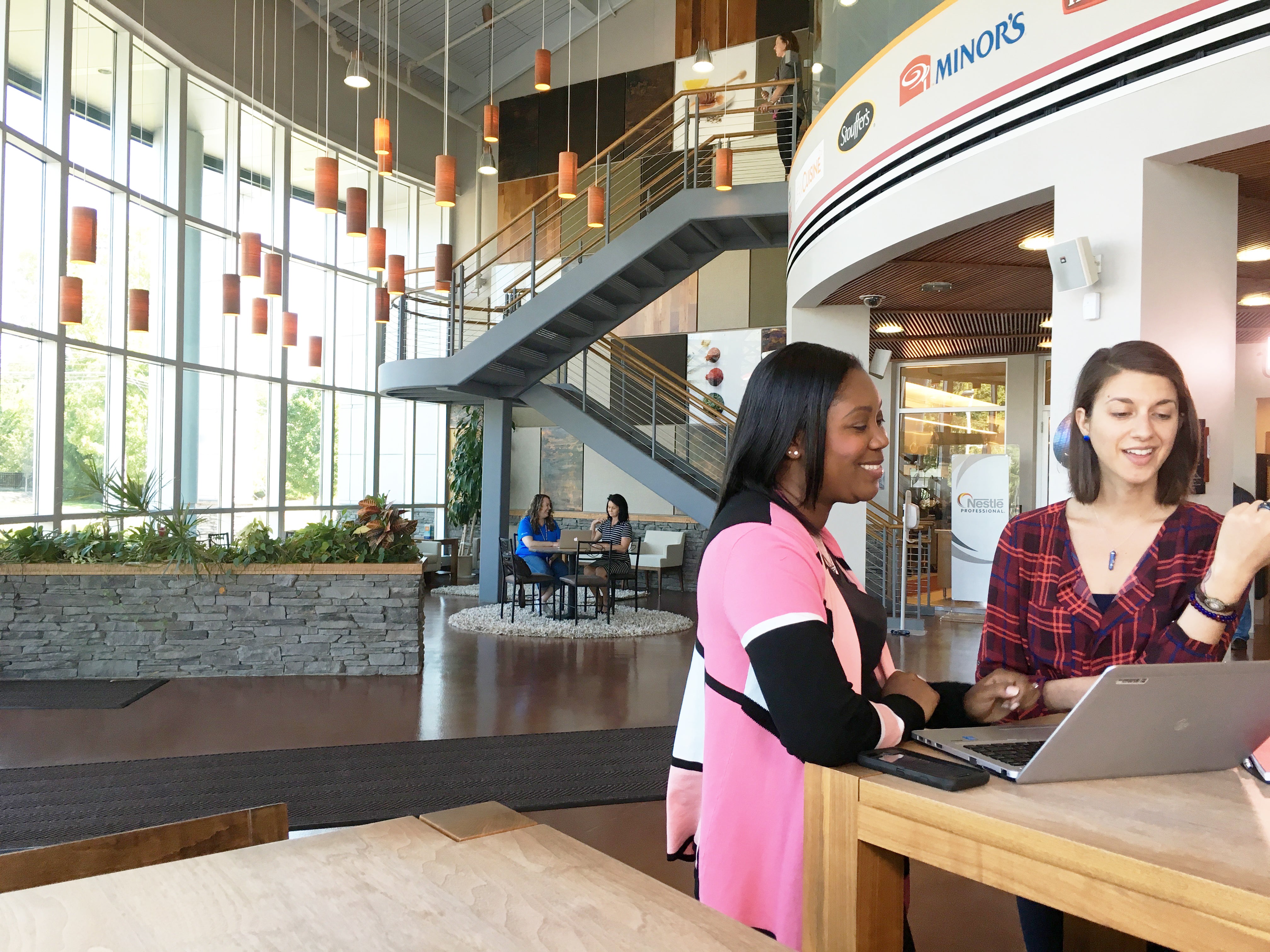Two females talking in the lobby of an office building  