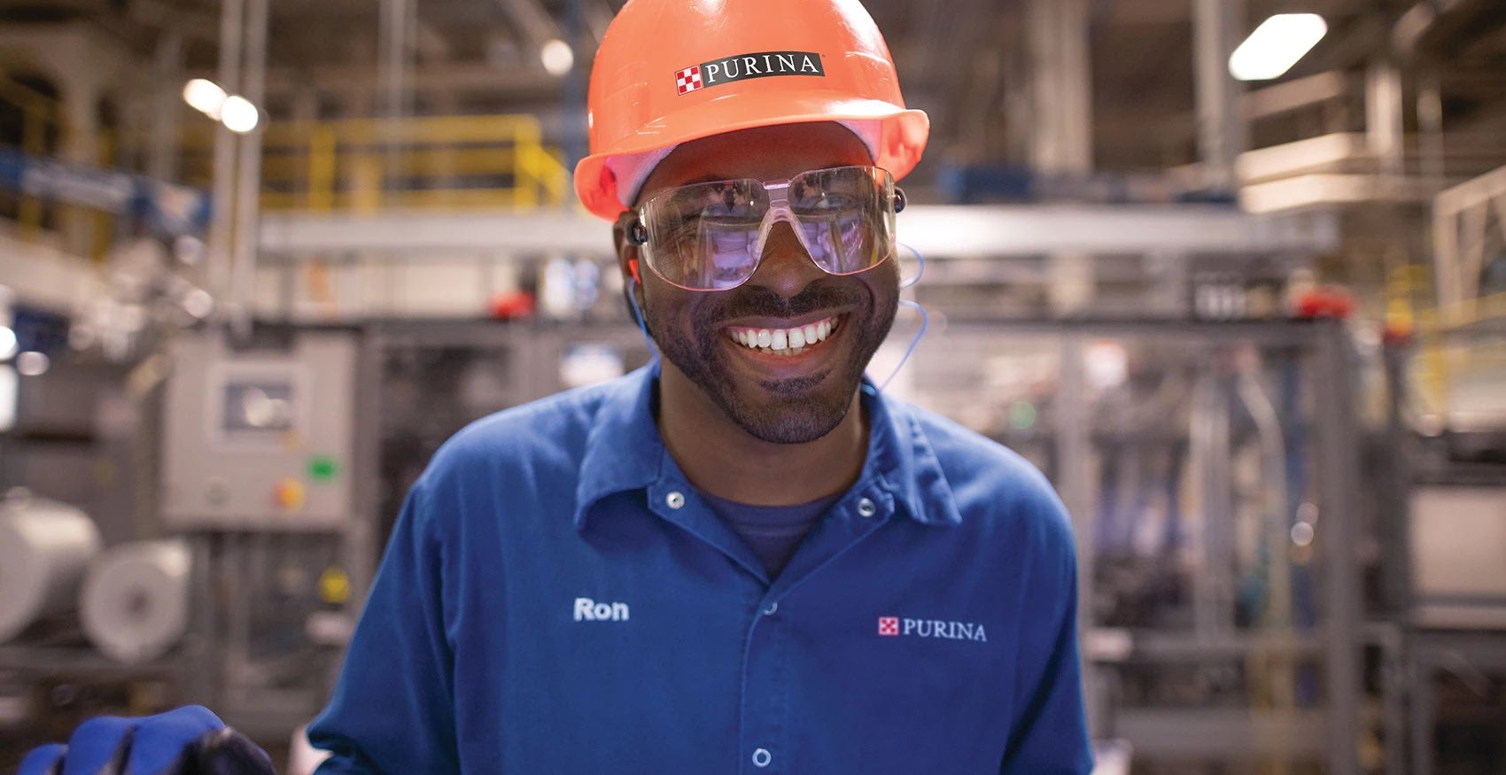 Headshot of Purina factory worker wearing an orange hard hat