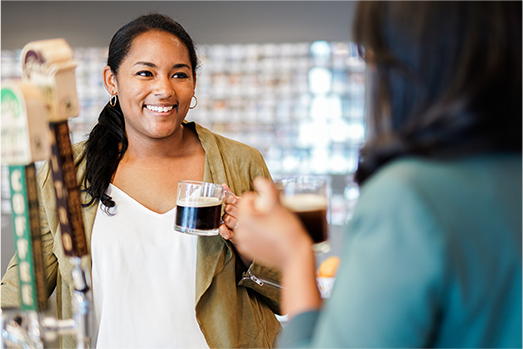 Two female Nestle employees drinking Nespresso talking and smiling