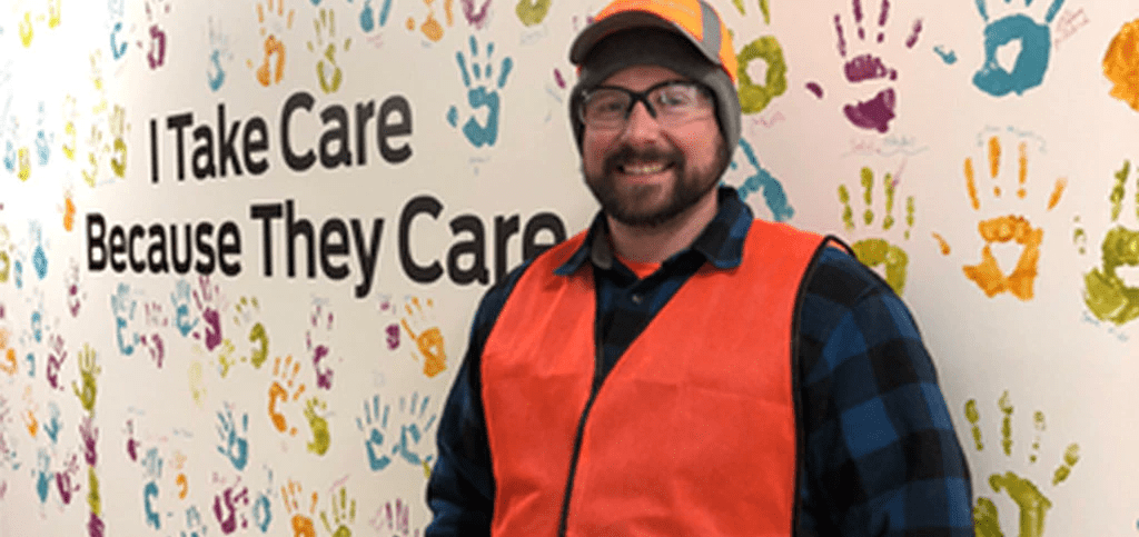 Nestlé Purina employee posing in front of a mural