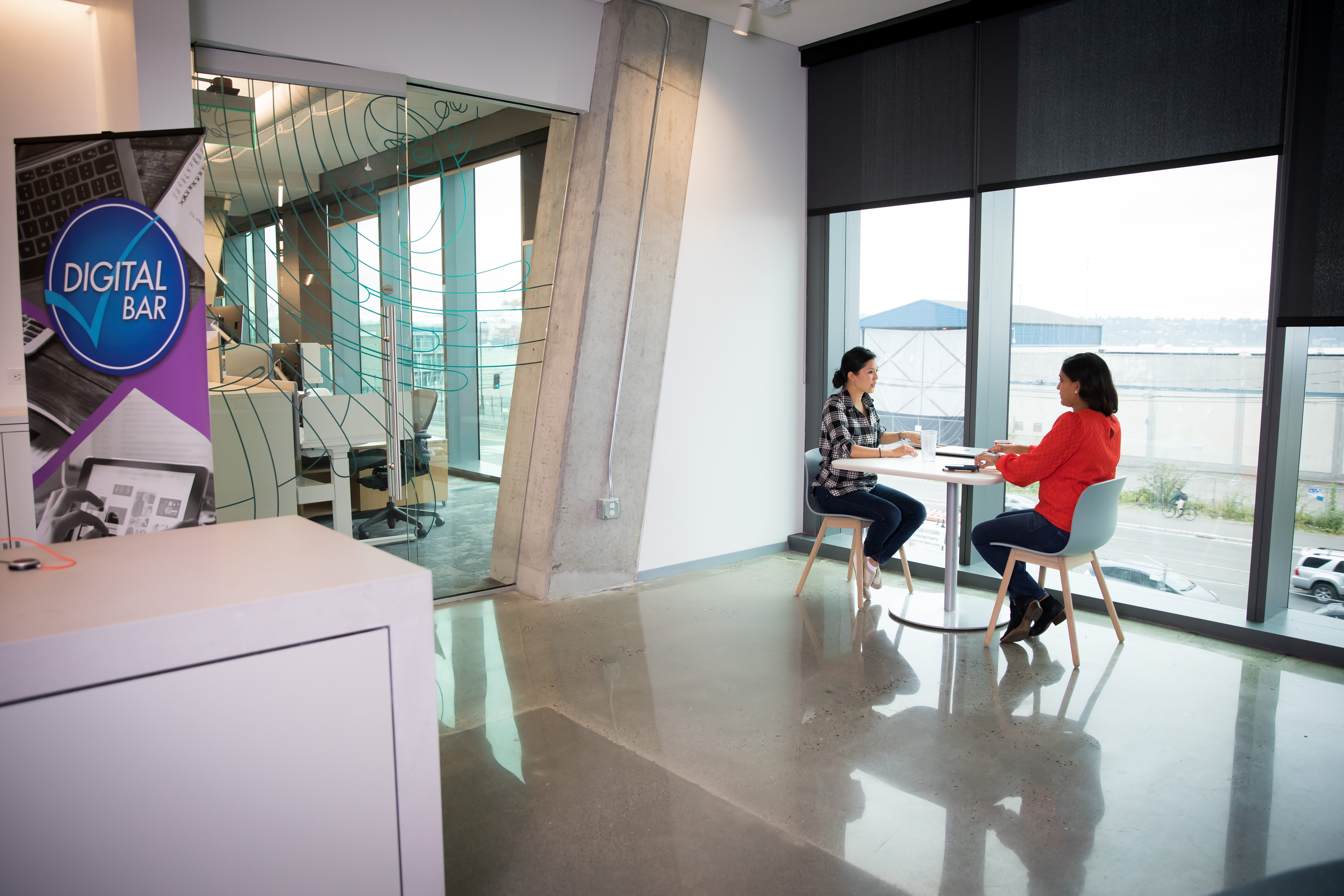Two female colleagues talking at a table
