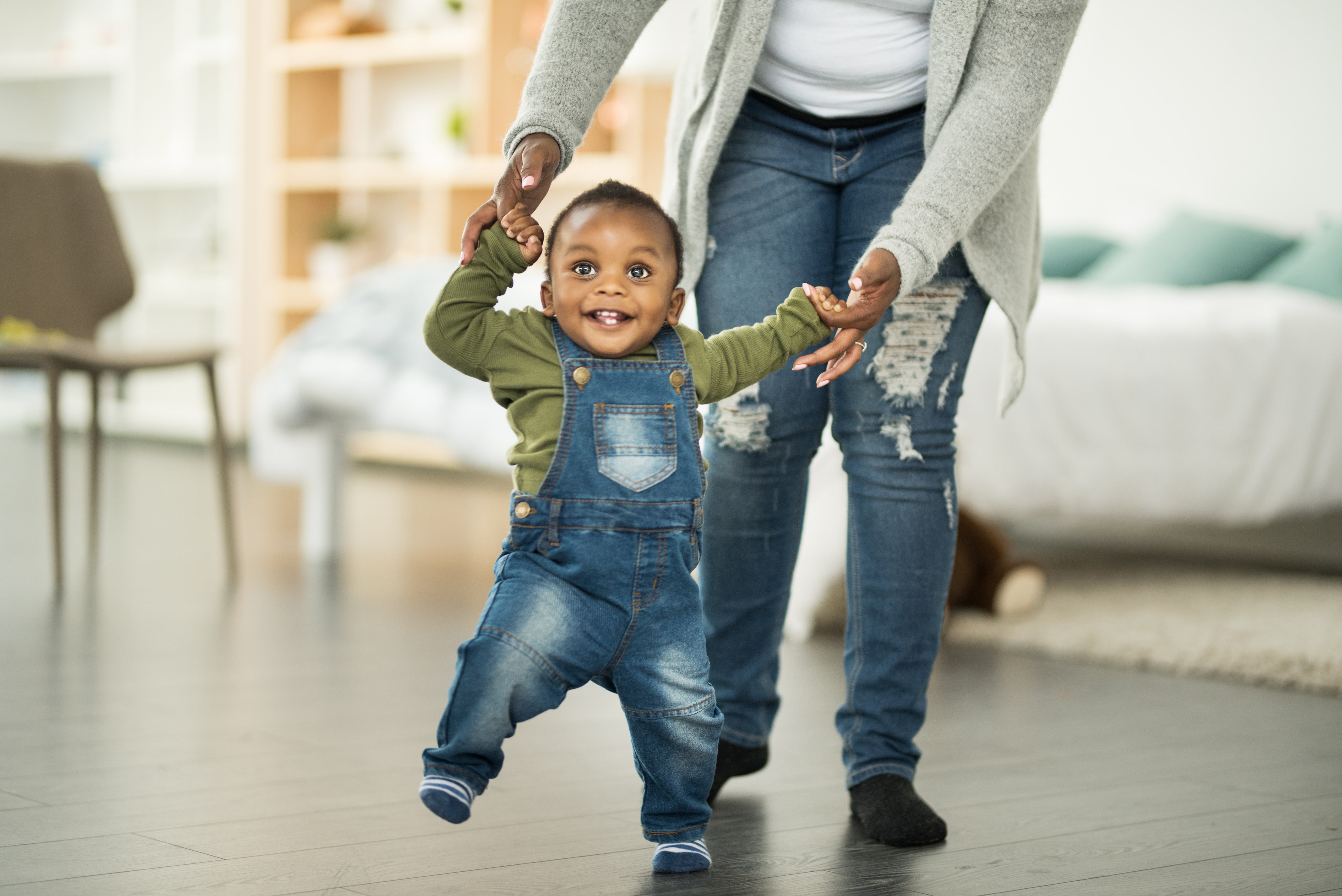 Baby walking with his parent
