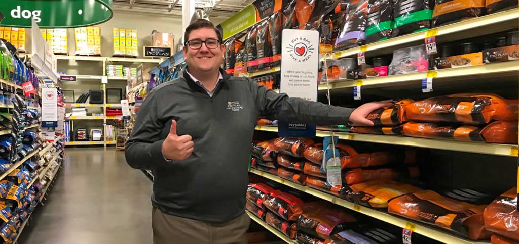 Nestlé Purina associate posing in front of products