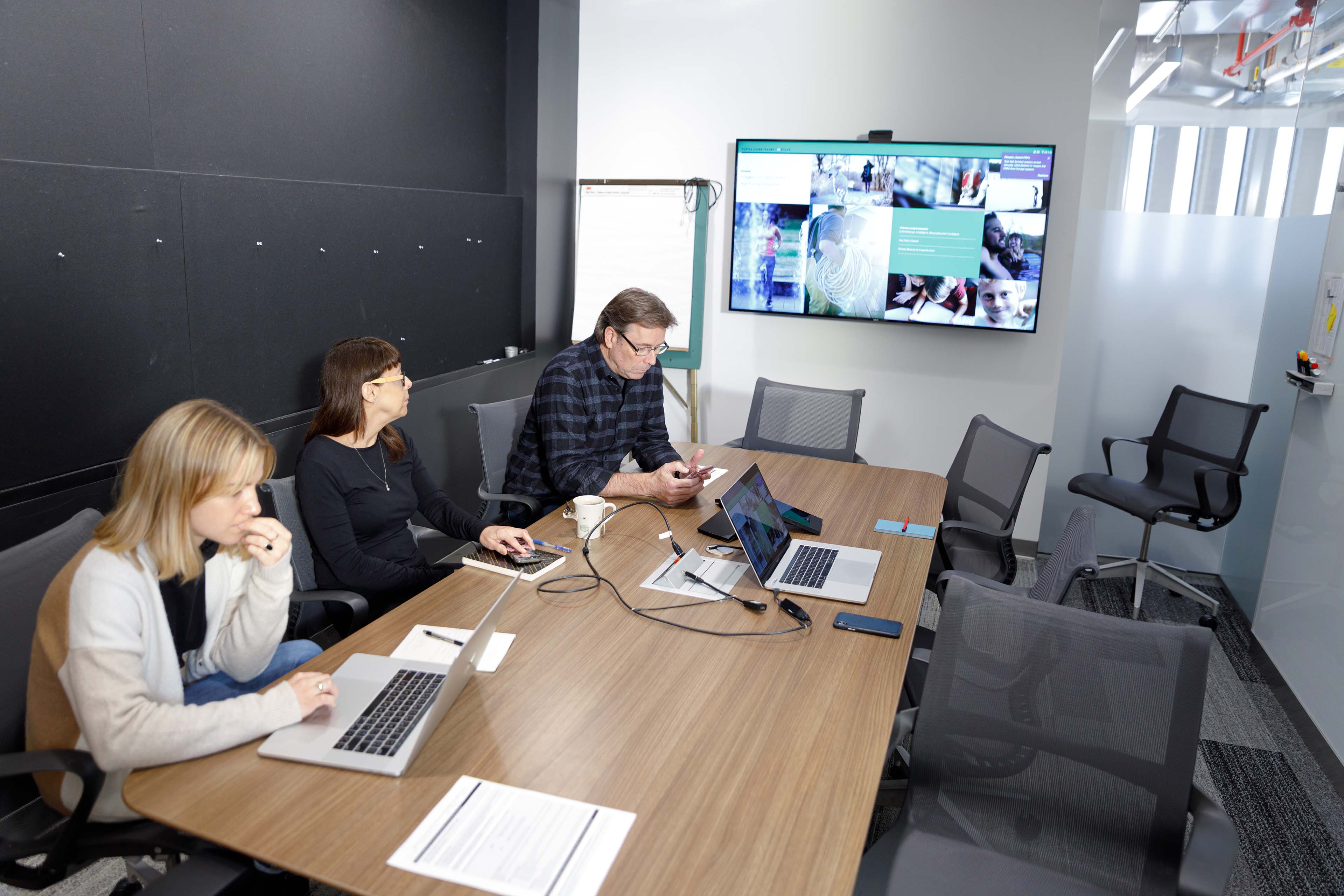 Group of people working on laptops in meeting room