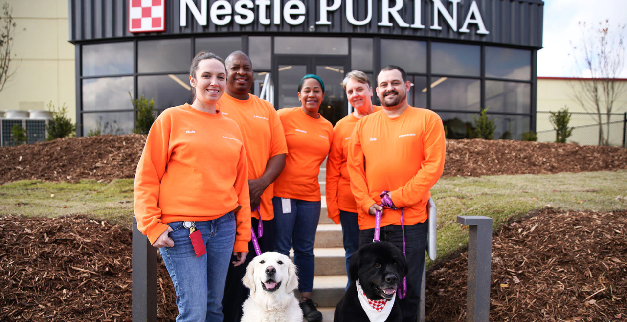 5 Purina workers posing outside of Hartwell factory
