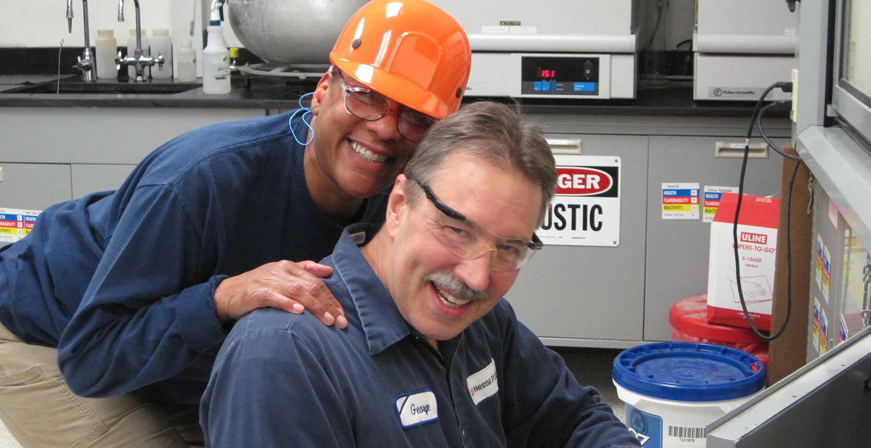 Associates smiling with hard hats and safety glasses on