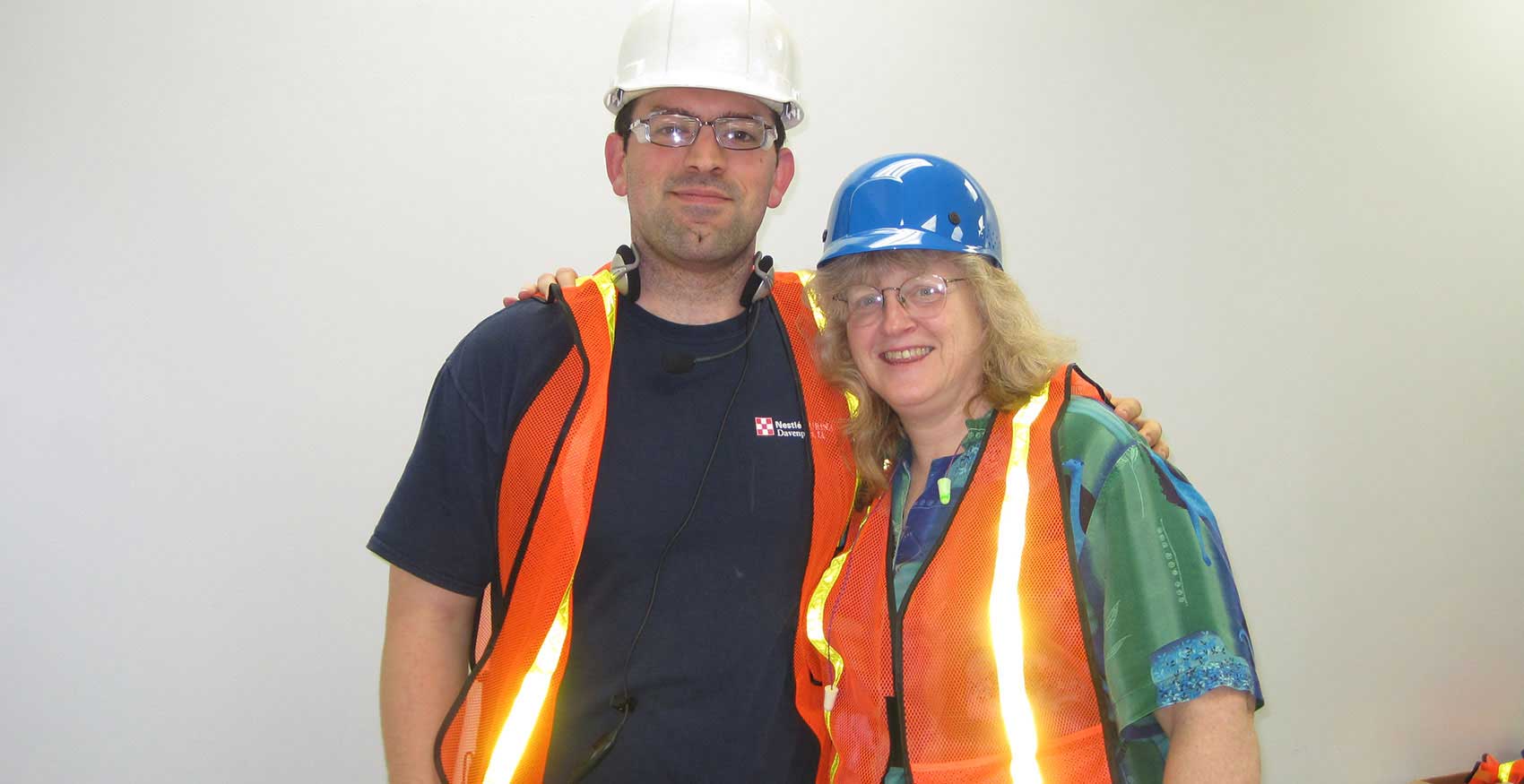 Associates smiling with hard hats and safety glasses on
