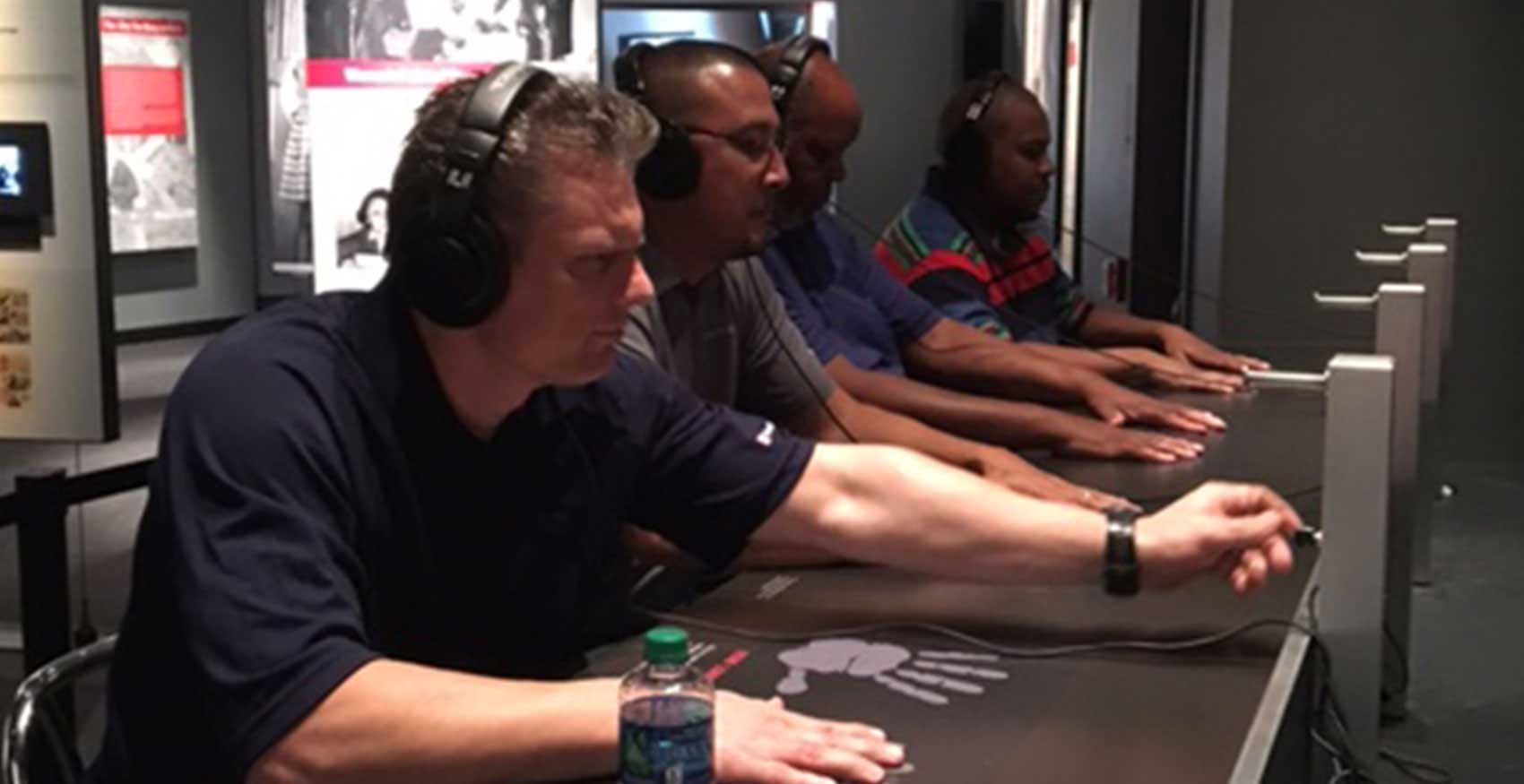 Associates sitting at table with headphones on