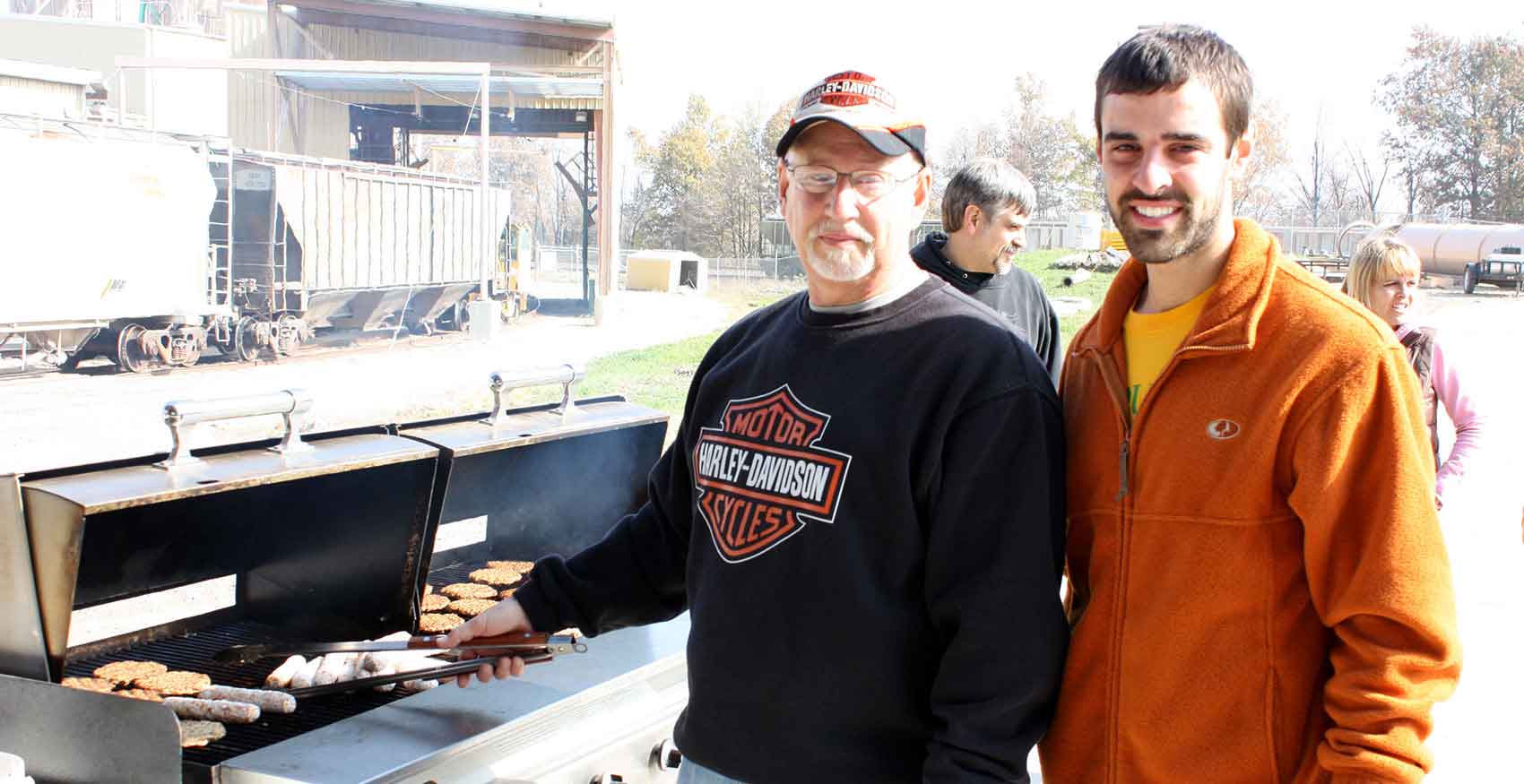 Men standing at grill cooking