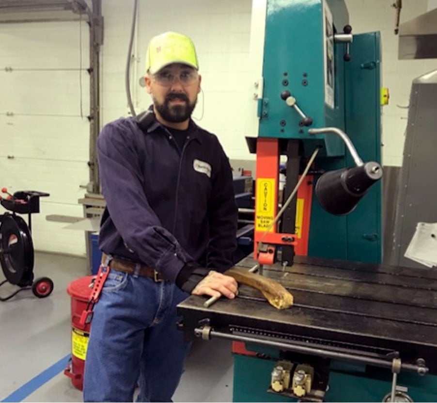 Cody working on a machine in the factory