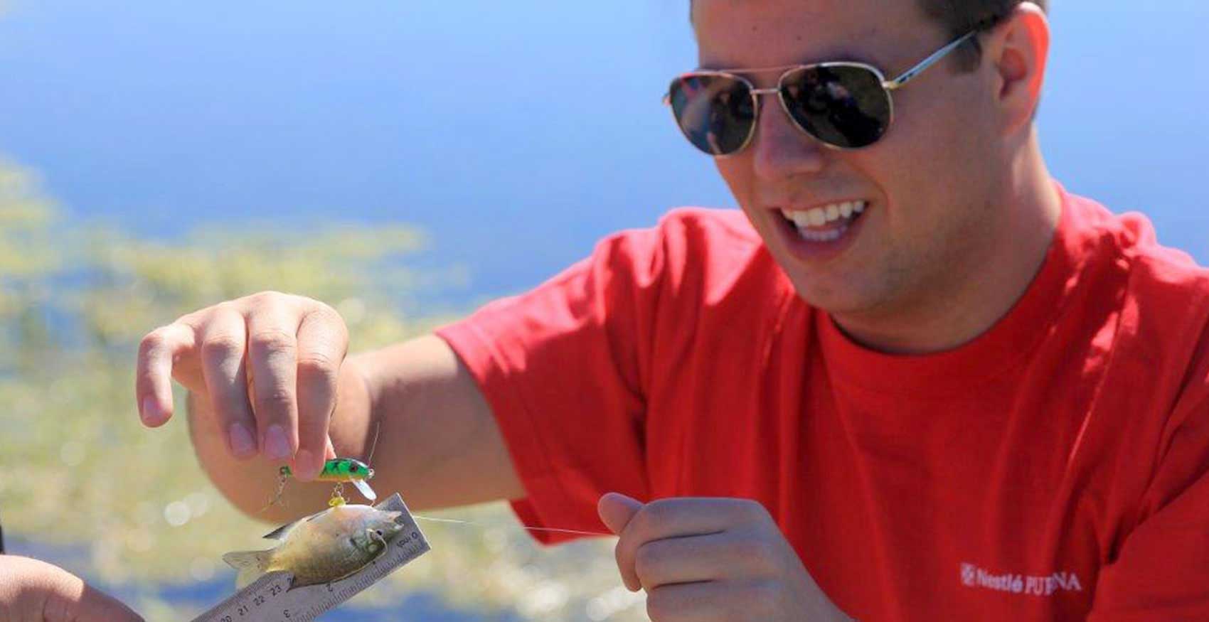 Man measuring fish on tape measure