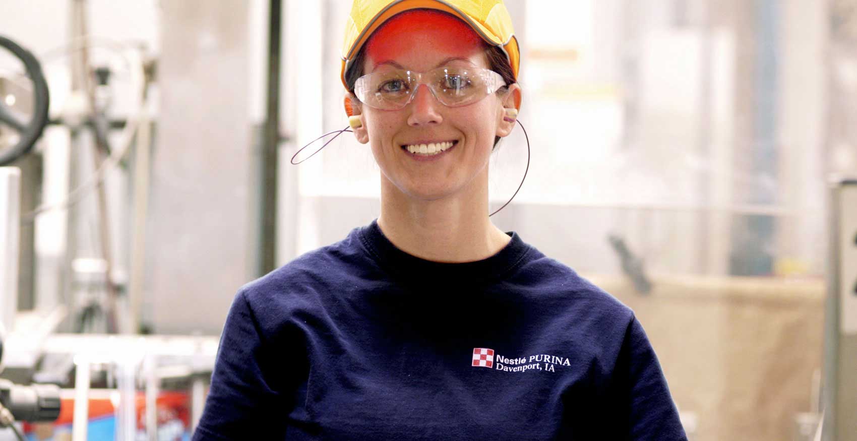 Woman standing and smiling with safety glasses on