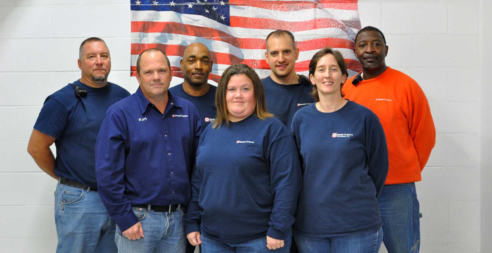 Associates standing in front of American flag painting