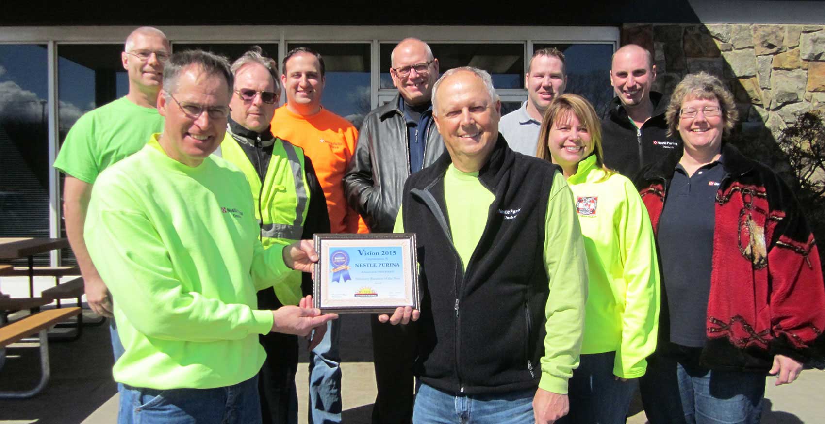 Dunkirk associates holding a plaque