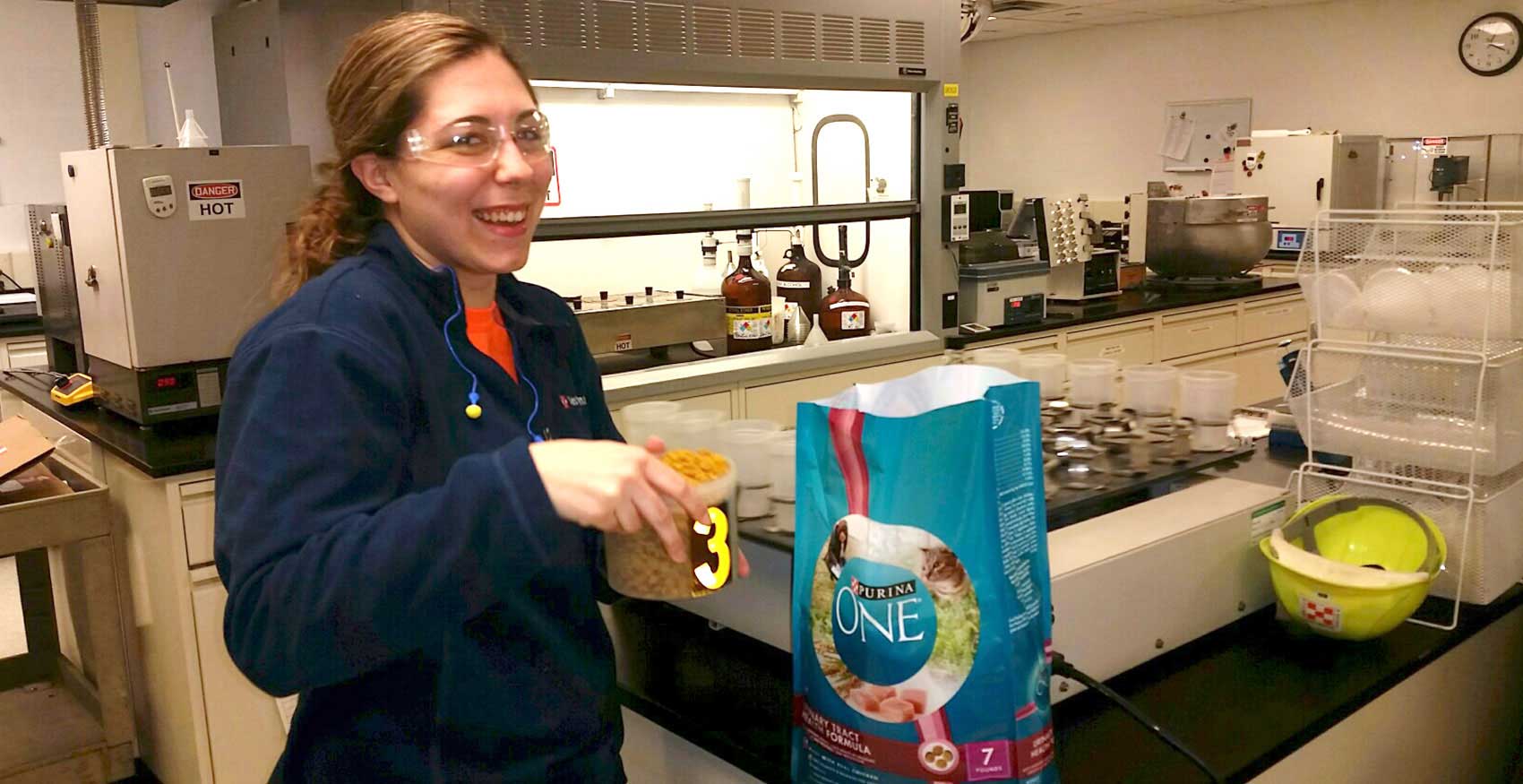 Associate standing with bowl of Purina One in hand
