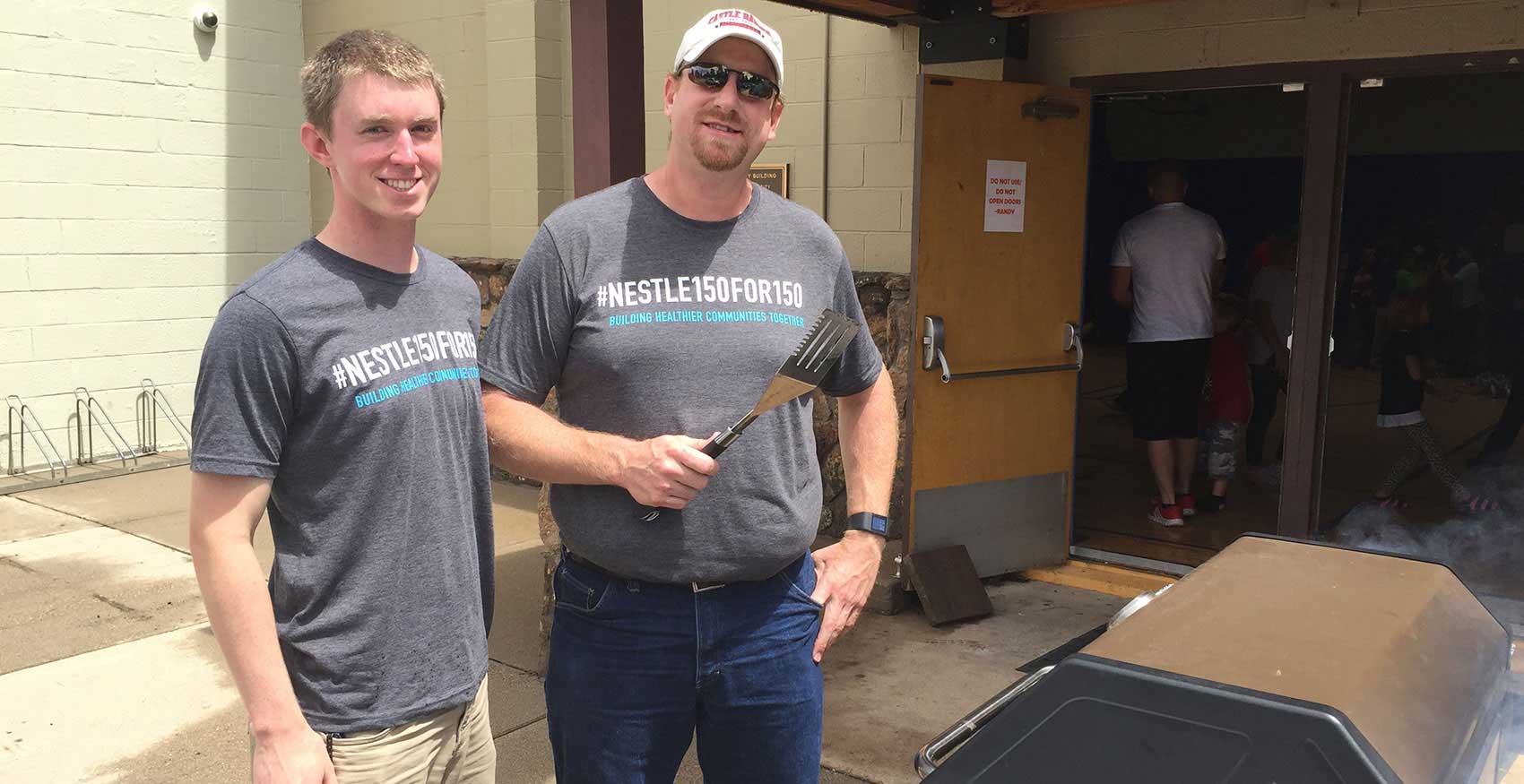 Men standing outside at BBQ pit