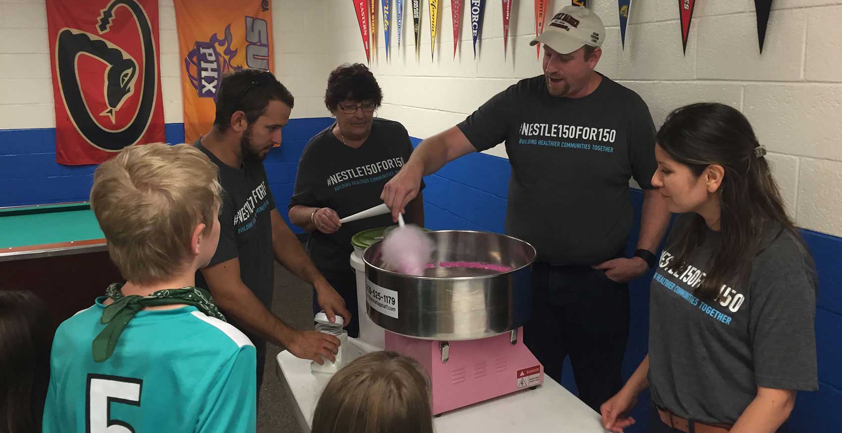 Group of people standing at cotton candy maker