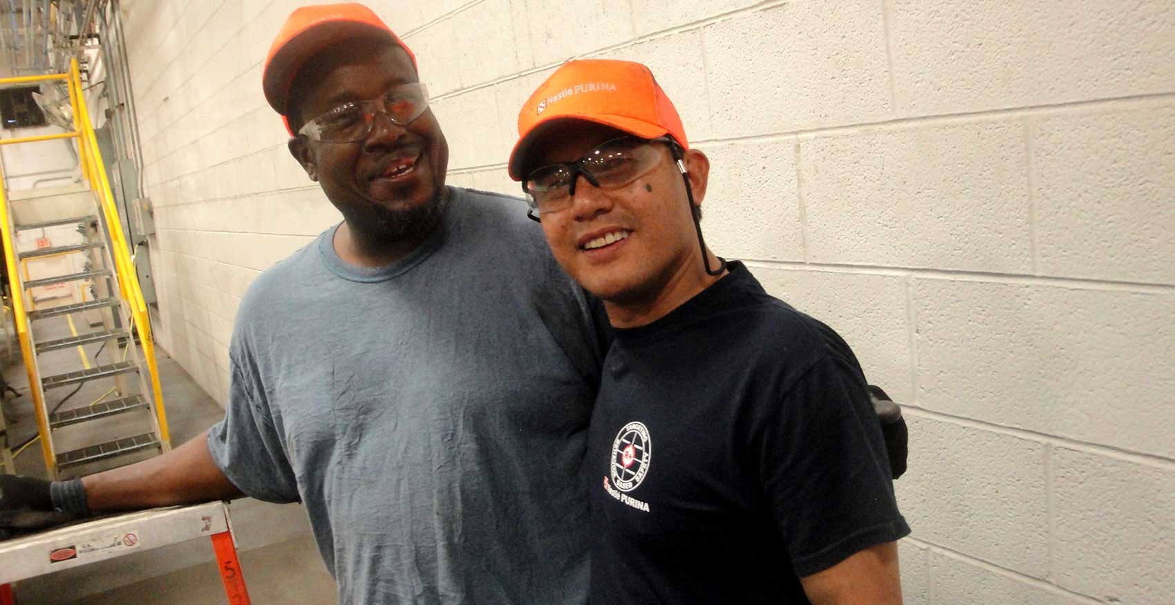 Two men smiling with safety glasses on