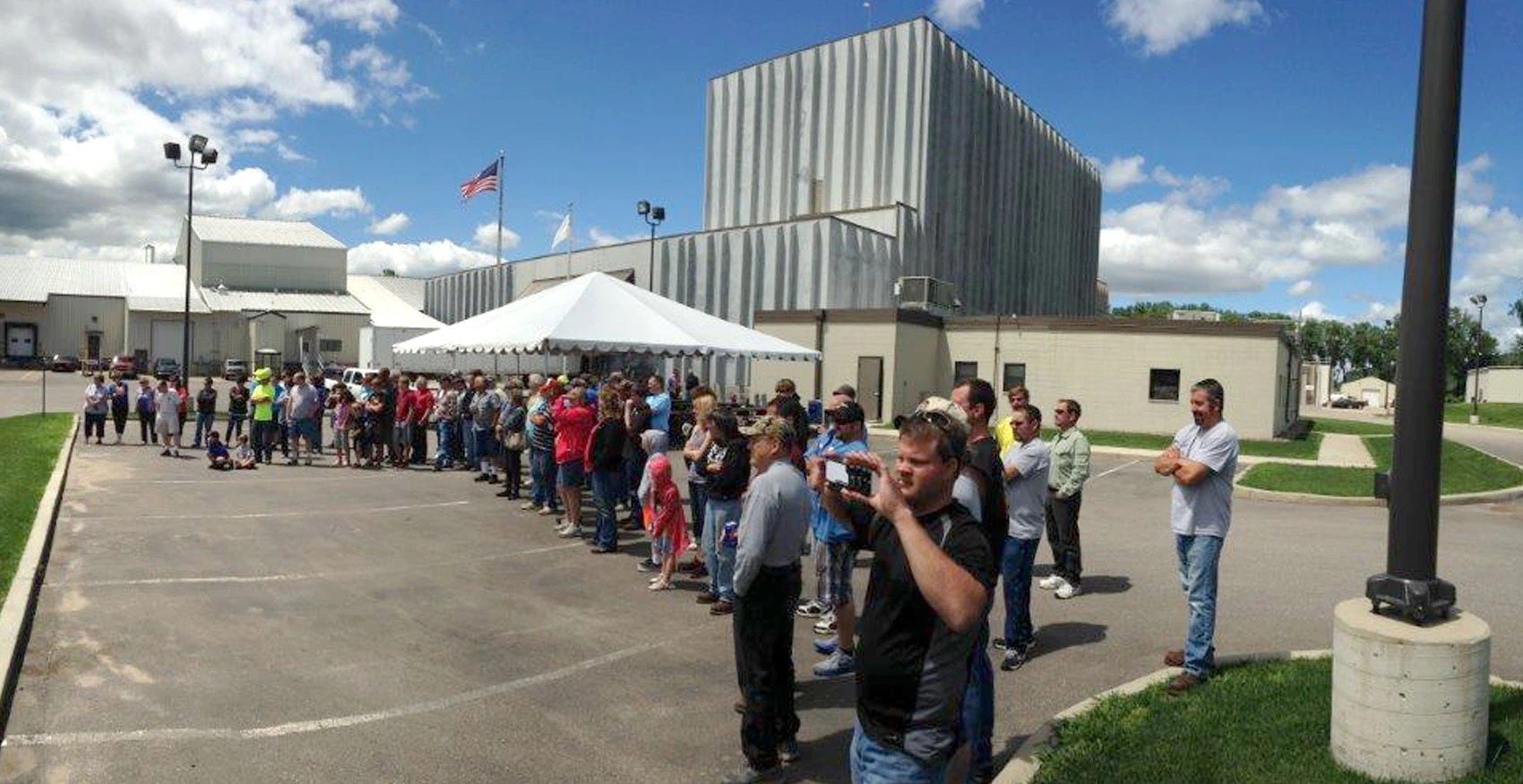 Line of people standing outside Hager City factory