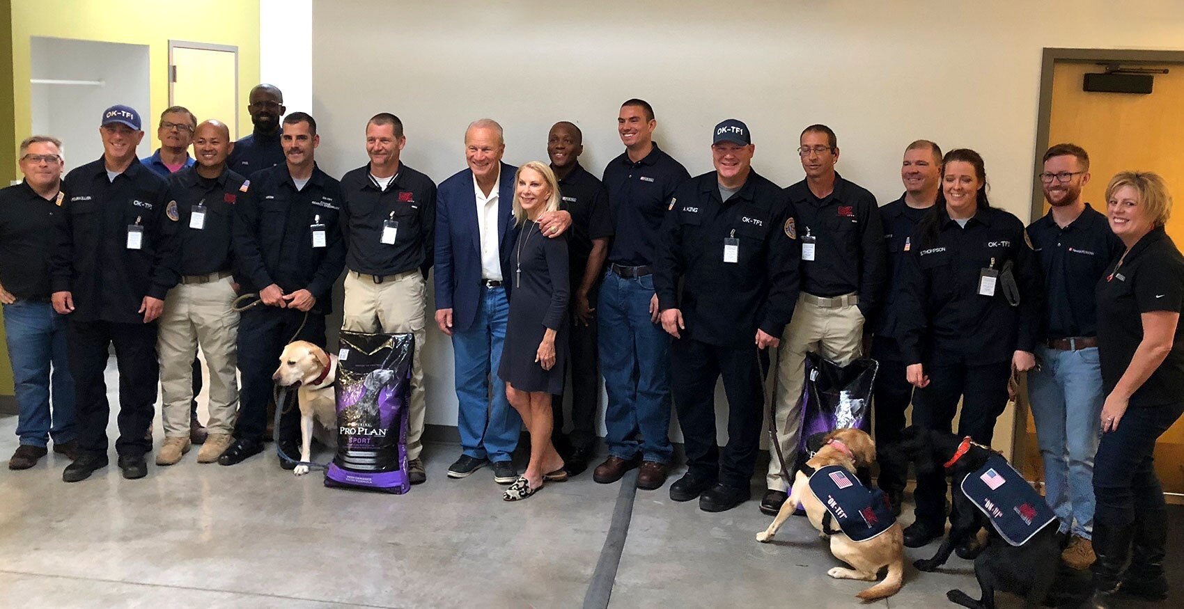 Group of people standing together with dogs and Purina Pro Plan bags