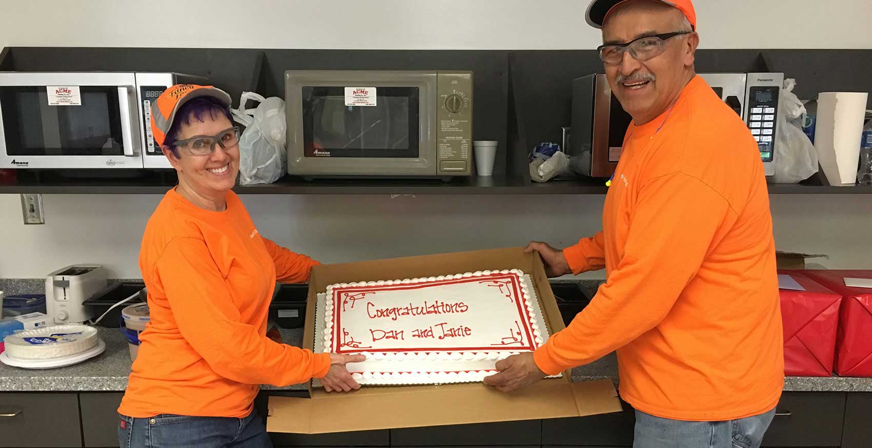 Man and woman holding congratulations cake