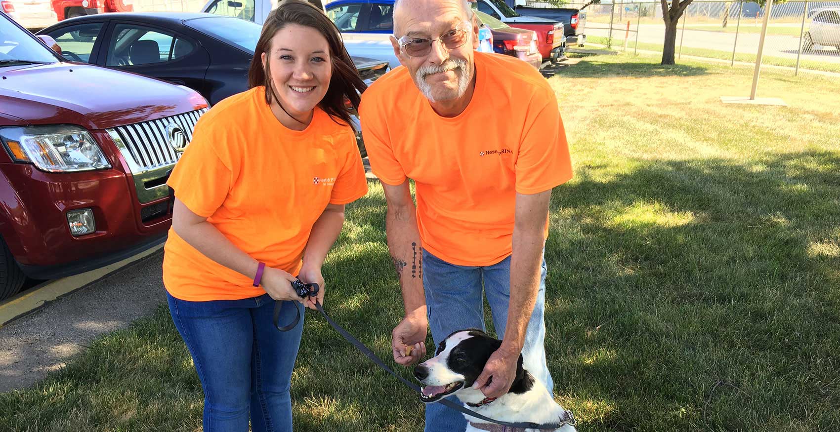 Man and woman smiling with dog