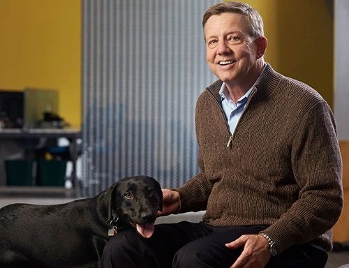 Man sitting with dog next to him