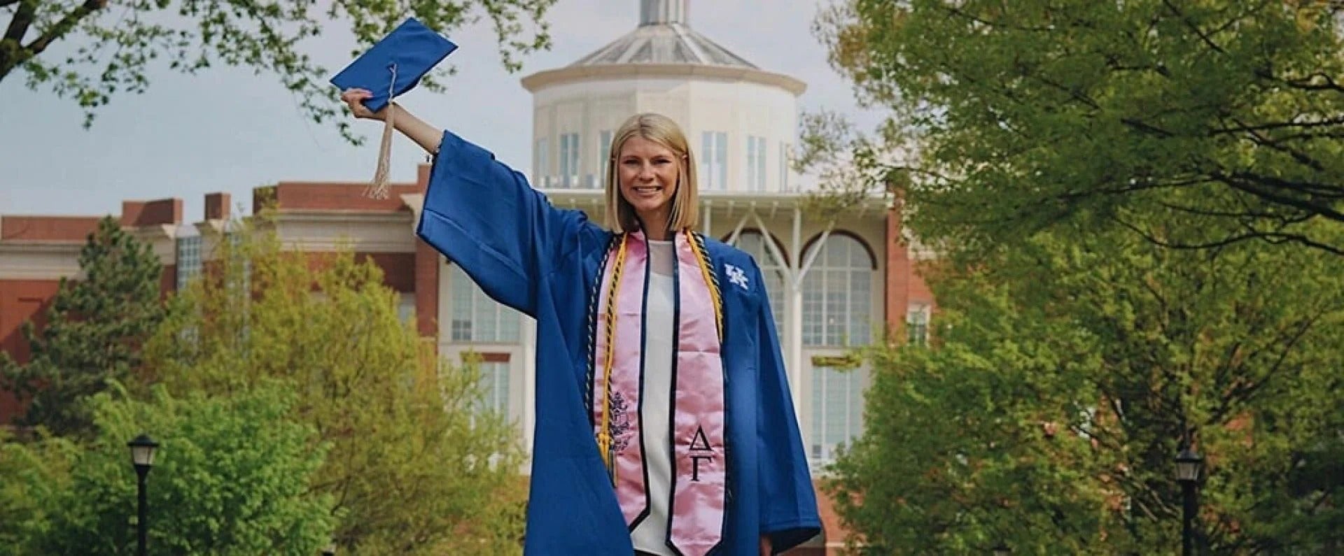 A graduate stands on the university background