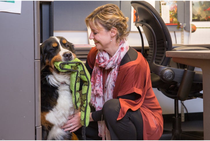 Woman petting her dog in her office