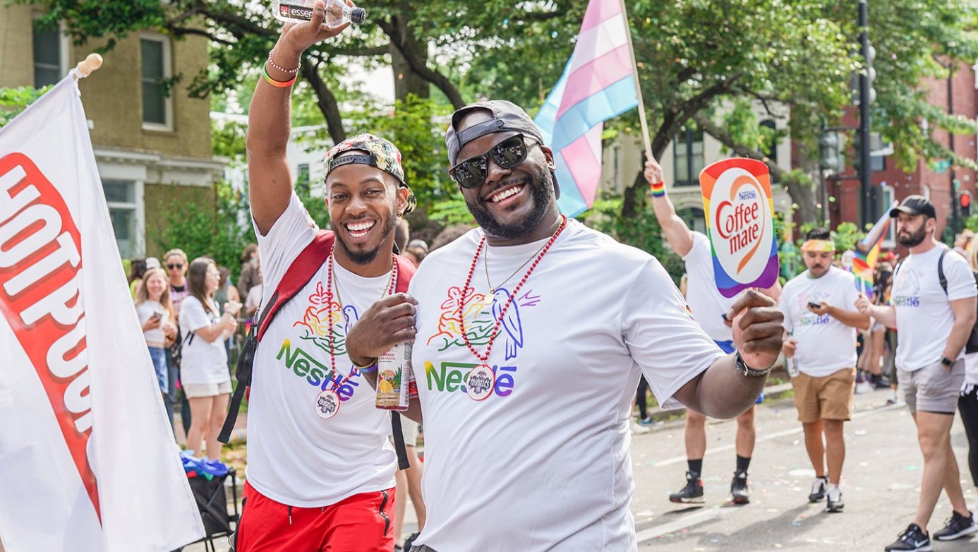 Two Nestle employees walking in a Pride parade