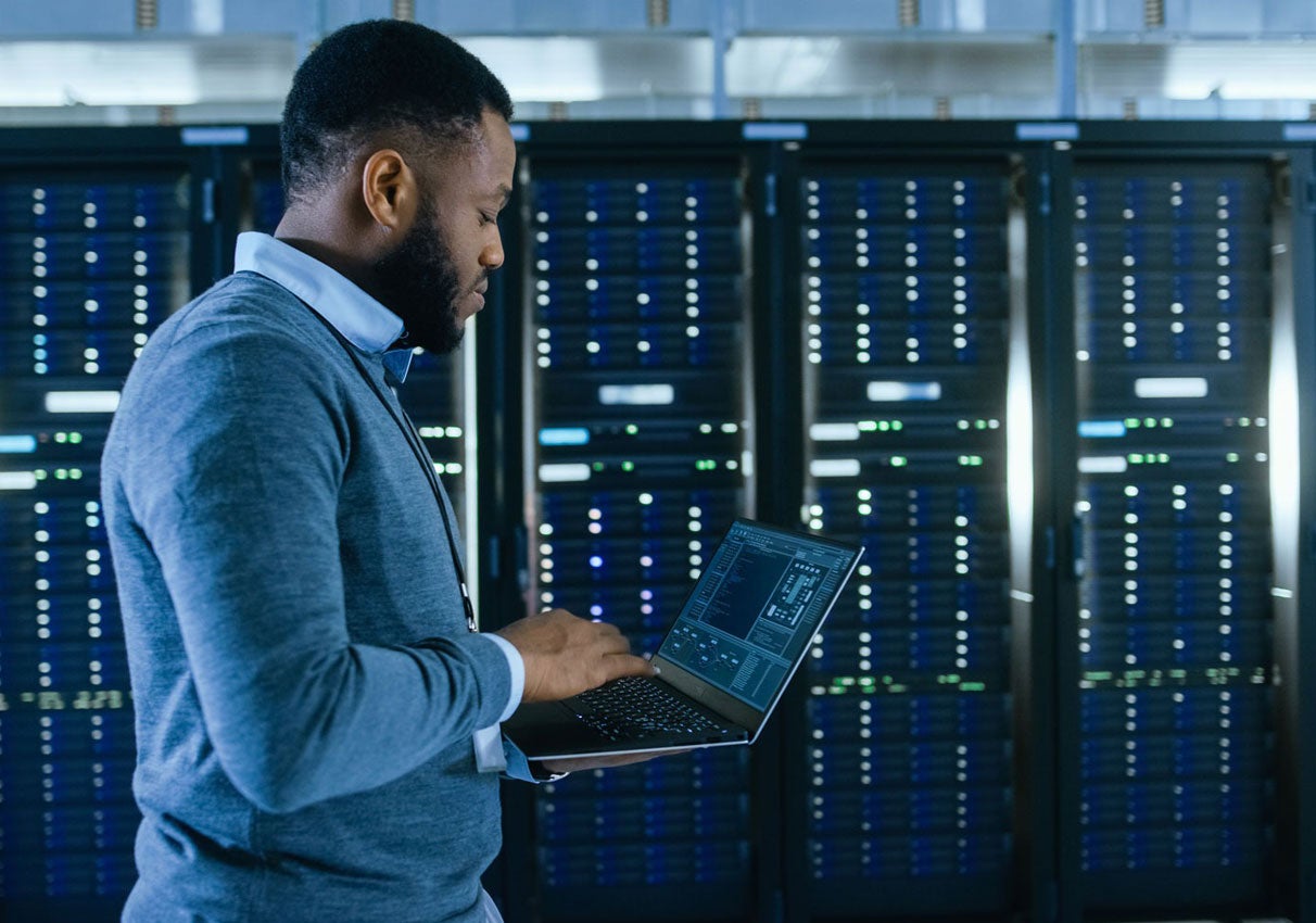 IT employee on computer in server room