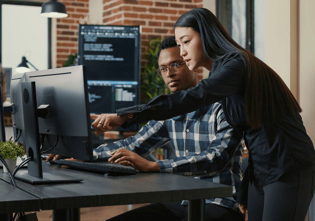 Two employees reviewing computer screen