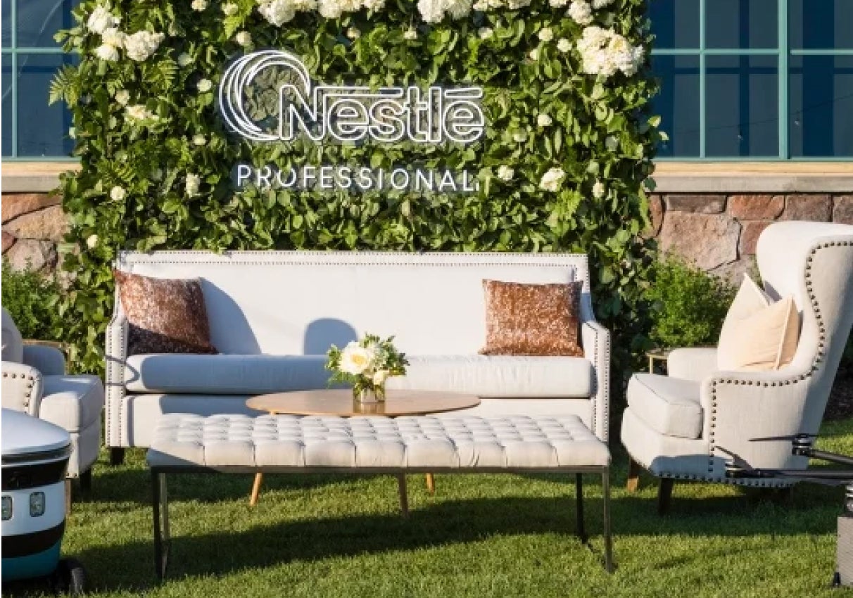 Couch and chair with a coffee table outside in grass