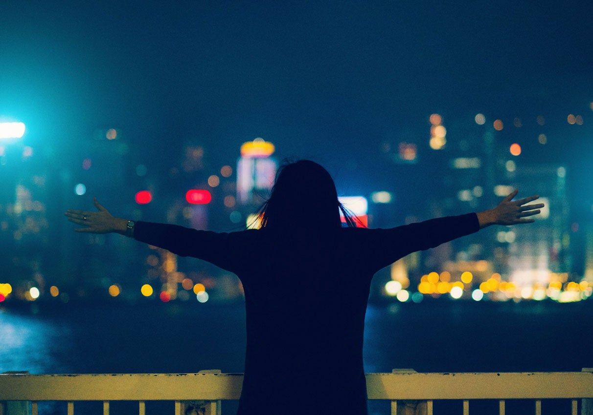 person in front of district wharf at night