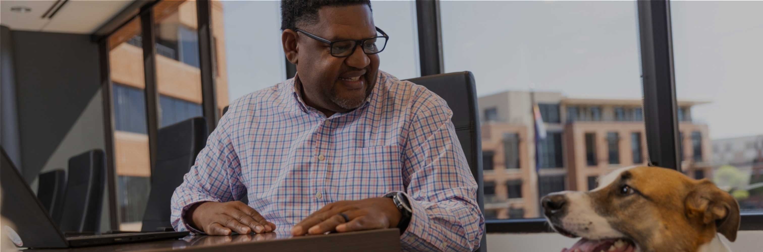 worker looking at dog in office