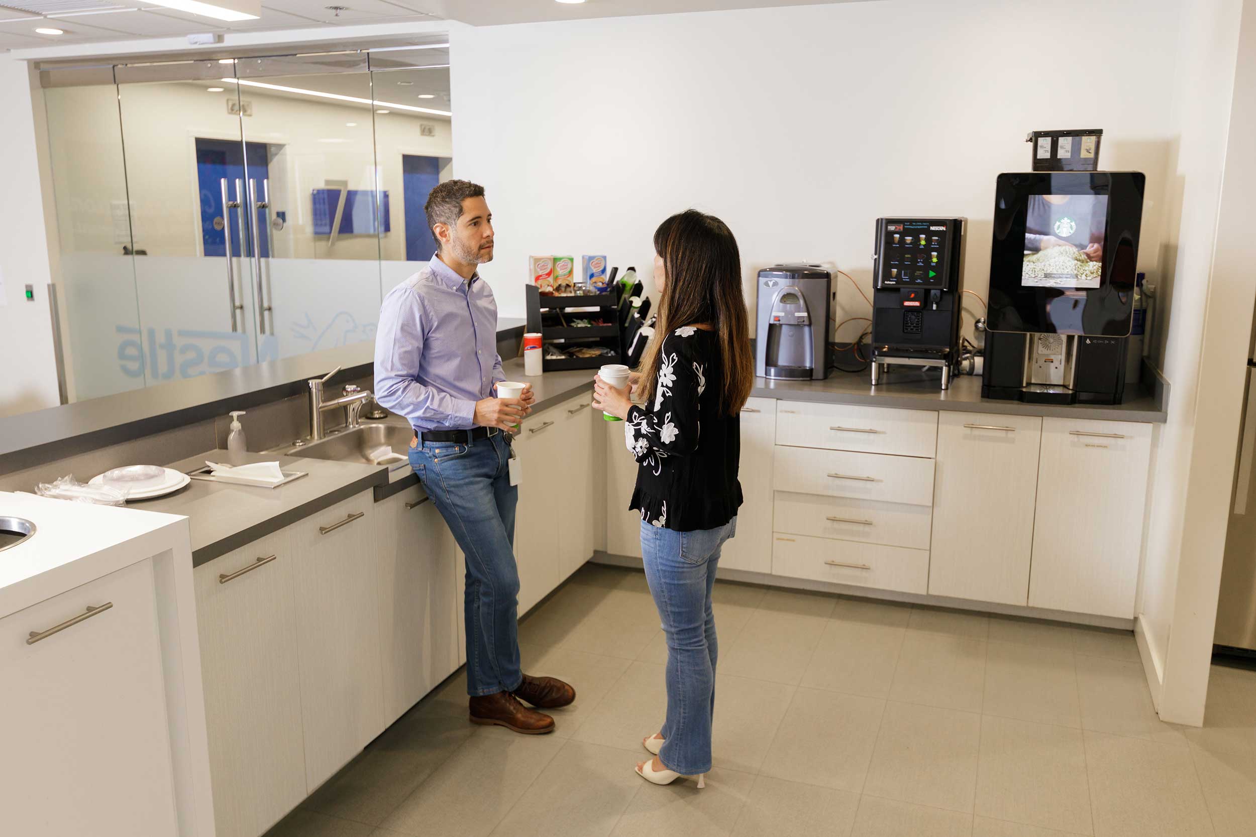 two associates chatting in the kitchen break room